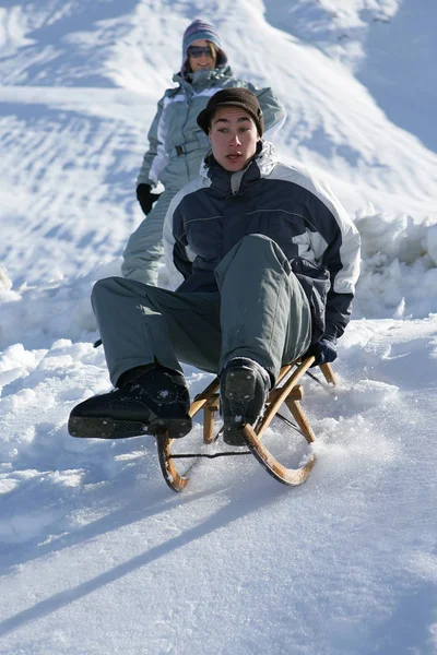 年轻人在雪地里做雪橇 — 图库照片