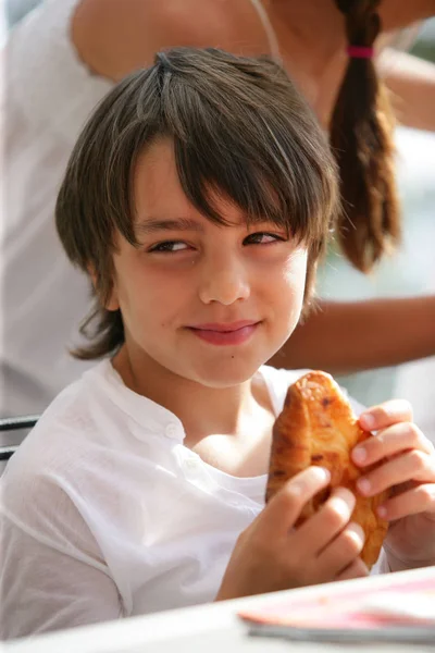 Retrato Niño Sentado Mesa Con Croissant Las Manos —  Fotos de Stock
