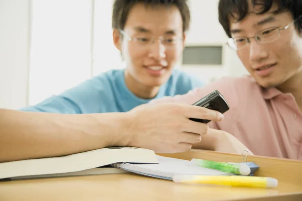 Twee Aziatische Mannen Die Naar Een Mobieltje Van Een Derde — Stockfoto