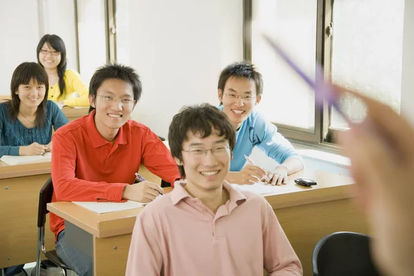 5个亚洲学生在教室里笑着看着前方 — 图库照片