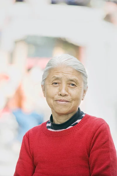 Starsza Kobieta Plenerze Patrzy Kamerę Głowa Ramiona Widoczne Strzał Pionie — Zdjęcie stockowe