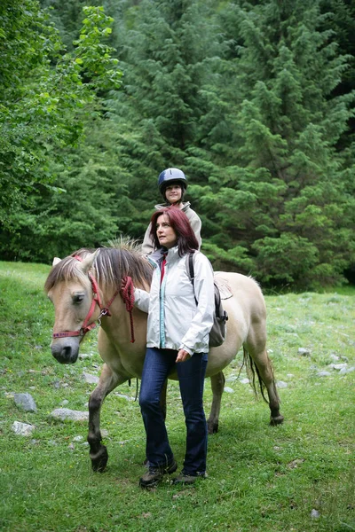 Vrouw Loopt Buurt Van Een Meisje Zittend Een Pony — Stockfoto