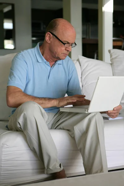 Senior Man Zittend Een Bank Voor Een Laptop — Stockfoto