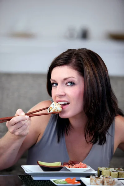 箸で寿司を食べる女性の肖像画 — ストック写真