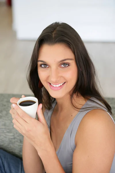 Retrato Uma Mulher Sorrindo Sentada Sofá Com Uma Xícara Café — Fotografia de Stock