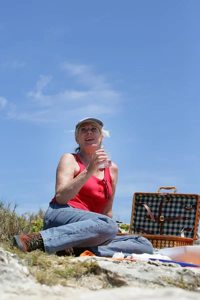 Vrouwelijke Senior Picknick Met Een Glas Water Met Hand — Stockfoto