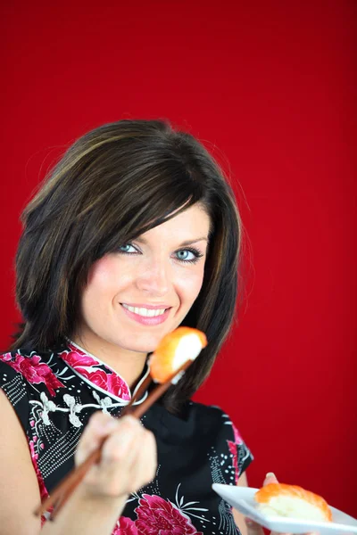 Retrato Uma Mulher Comendo Sushi Com Pauzinhos Fundo Vermelho — Fotografia de Stock