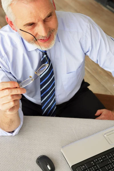 Senior Man Zit Achter Een Bureau Voor Een Laptop — Stockfoto