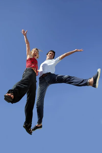 Man and woman jumping in the air face