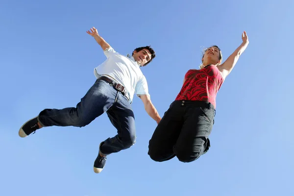 Man and woman jumping in the air face