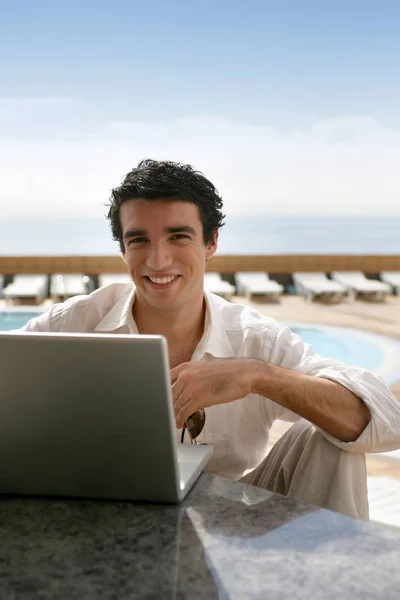 stock image Smiling man with laptop back to the sea front