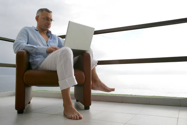 Man Zittend Een Fauteuil Het Terras Met Laptop Zeeprofiel — Stockfoto