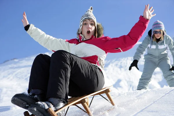 雪の中でそりを作る若い女性 — ストック写真