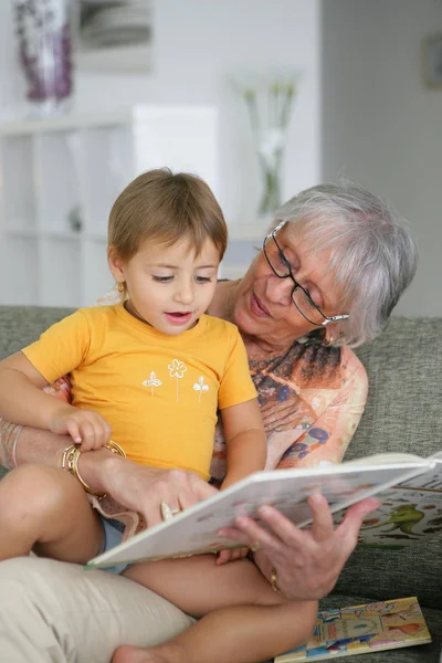 年配の女性と子供のための本を読む少女の肖像 — ストック写真