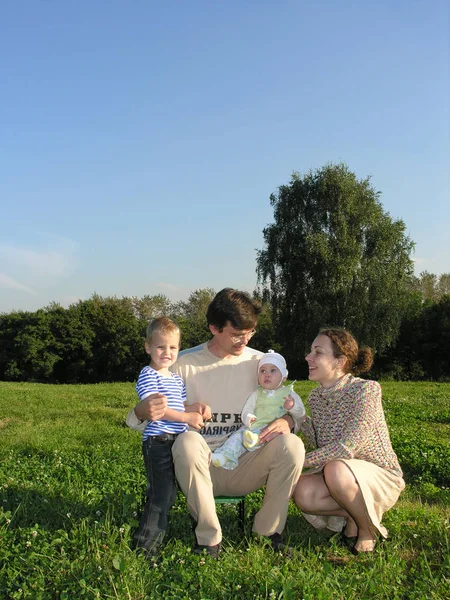 Familia Cuatro Hierba Madera Cielo Azul Sin Nubes Sentarse Sonrisa — Foto de Stock