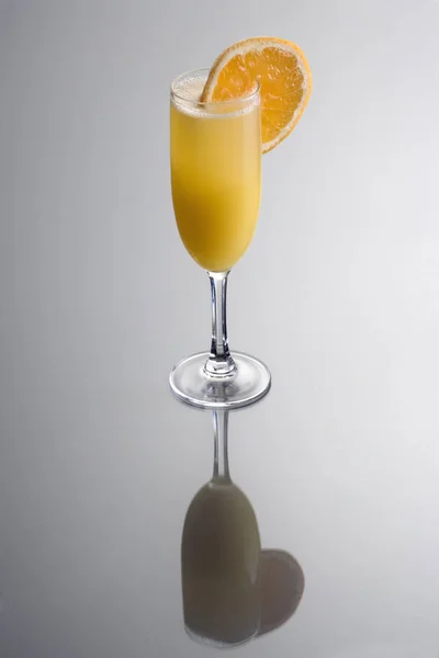 Mimosa Gemengde Drank Met Sinaasappelschijfje Garnering Grijze Achtergrond Met Reflectie — Stockfoto