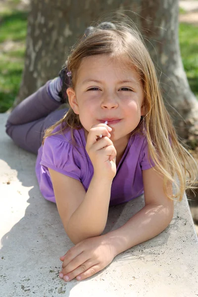 可愛いです若いです女の子楽しみます吸いAロリポップ — ストック写真