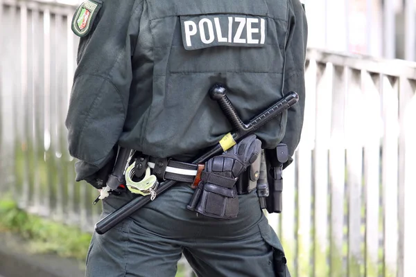 police officer with uniform and gun in the background