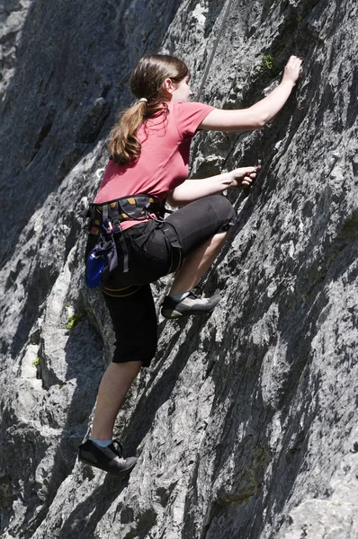 若い女性が岩の上に登り — ストック写真