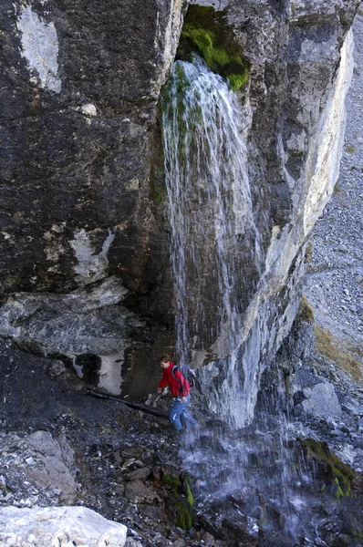 Πεζοπόρος Διασχίζοντας Ένα Δροσιστικό Καταρράκτη Άλπεις Στο Φόντο Της Φύσης — Φωτογραφία Αρχείου