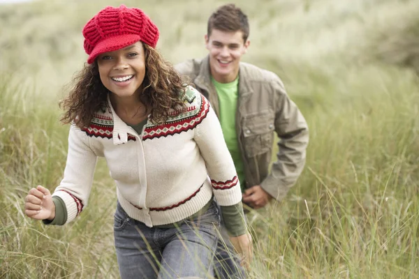 青少年情侣穿上保暖衣服在沙坑中漫步 — 图库照片