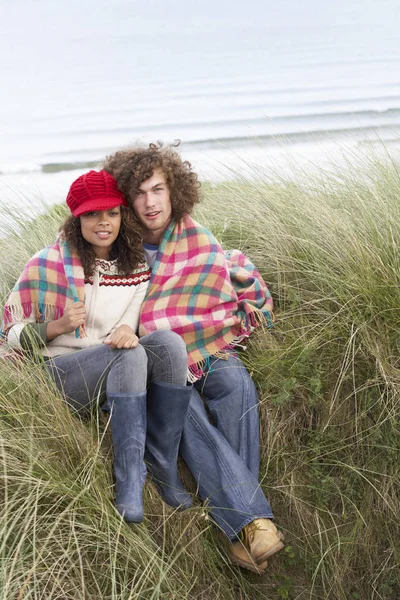 Casal Jovem Sentado Dunas Areia Envolto Cobertor — Fotografia de Stock