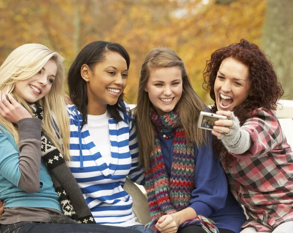 Skupina Čtyř Dospívajících Dívek Fotografování Kamerou Sedí Lavičce Podzim — Stock fotografie