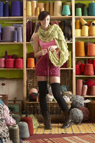 年轻女子针织围巾站在纱显示前 — 图库照片