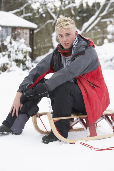 Teenage Boy Sledge Vedle Sněhuláka — Stock fotografie