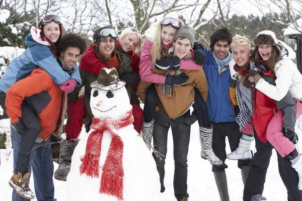 Grupy Nastoletnich Przyjaciół Budowa Snowman Ogrodzie — Zdjęcie stockowe