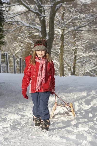 Mladá Dívka Táhnoucí Sledge Přes Zasněžené Krajiny — Stock fotografie