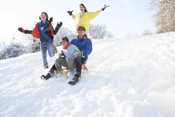 Familjen Som Har Roligt Att Kasta Sig Ner För Snöig — Stockfoto