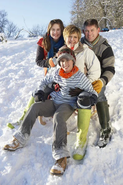 Familjen Njuter Sledging Snowy Hill — Stockfoto