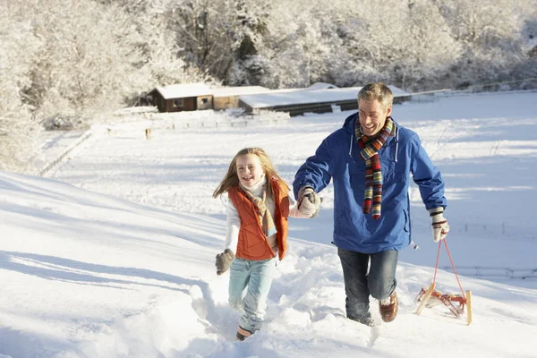 Far Och Dotter Drar Sledge Upp Snowy Hill — Stockfoto