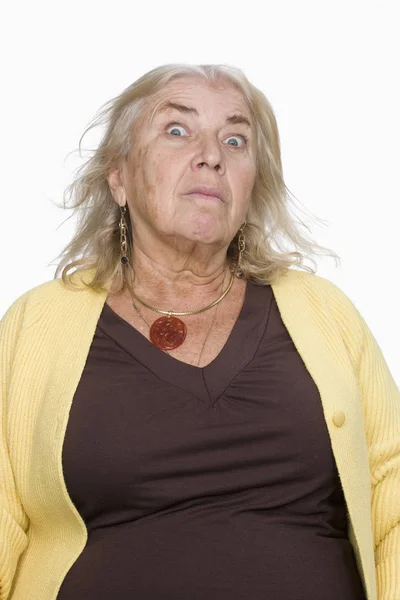一个穿着黄色毛衣的老年妇女的画像 她带着不祥的表情看着摄像机 垂直射击 与白种人隔离 — 图库照片