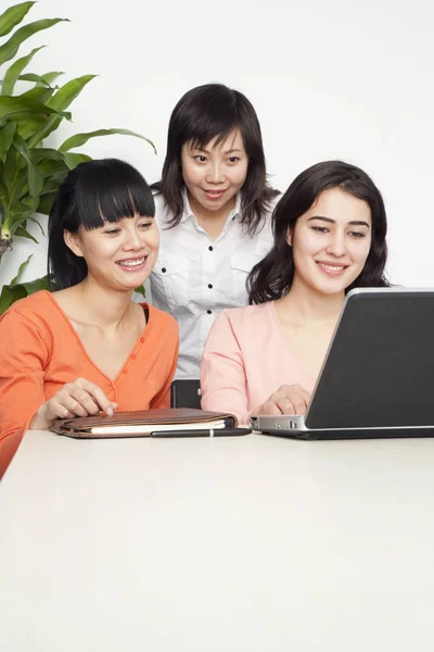 Atrakcyjne Młode Biznesmenki Uśmiechają Się Patrzą Informacje Laptopie Strzał Pionowy — Zdjęcie stockowe