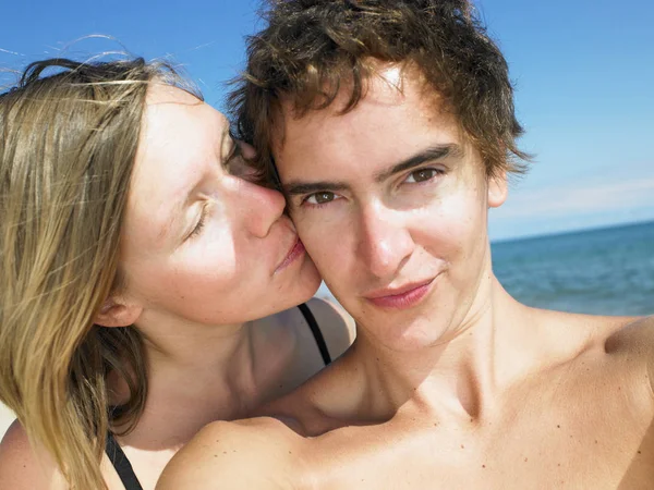 Młoda Kobieta Całująca Młodego Mężczyznę Policzek Podczas Pobytu Plaży Człowiek — Zdjęcie stockowe