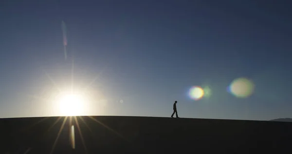 Widok Boku Człowieka Chodzącego Pustyni Słońcem Horyzoncie Strzał Poziomy — Zdjęcie stockowe