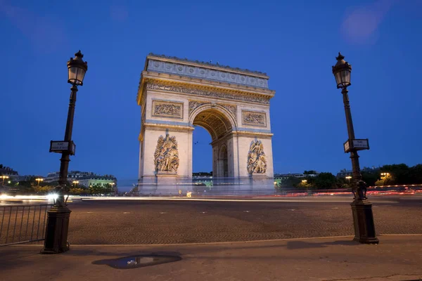 Alacsony Szögű Kilátás Arc Triomphe Keretezett Között Két Lámpaoszlop Alkonyatkor — Stock Fotó