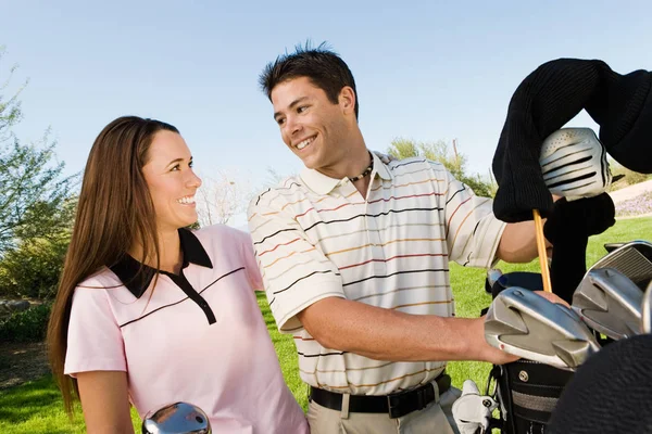 Golfing Pareja Agarrando Clubs —  Fotos de Stock