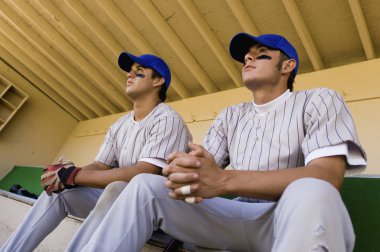 Baseball Players in Dugout Watching Game clipart