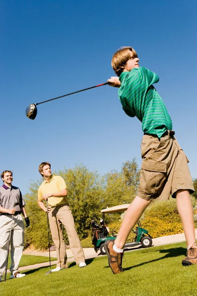 Golfer Teeing Mientras Los Amigos Vigilan — Foto de Stock