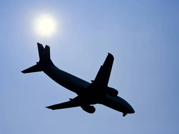 Silhueta Pouso Avião Contra Sol Brilhante — Fotografia de Stock