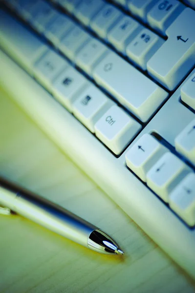 Close-up of a computer keyboard with a ballpoint pen