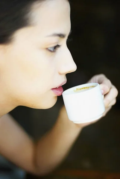 Side profile of a young woman holding a cup