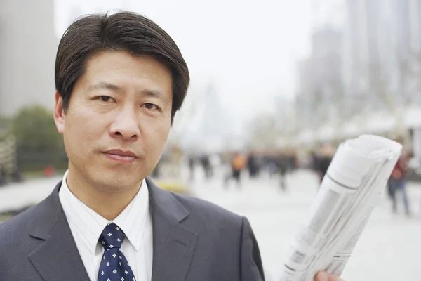 Portrait of a businessman holding a newspaper