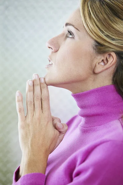 Side profile of a mid adult woman praying