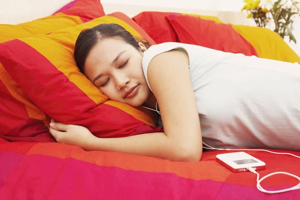Side profile of a young woman sleeping on the bed