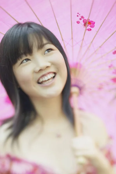 Portrait of a young woman holding a parasol smiling