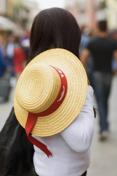 Side profile of a woman holding a hat